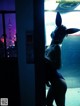 A woman wearing a bunny mask standing in front of a window.