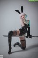 A woman in a bunny costume holding a sword.