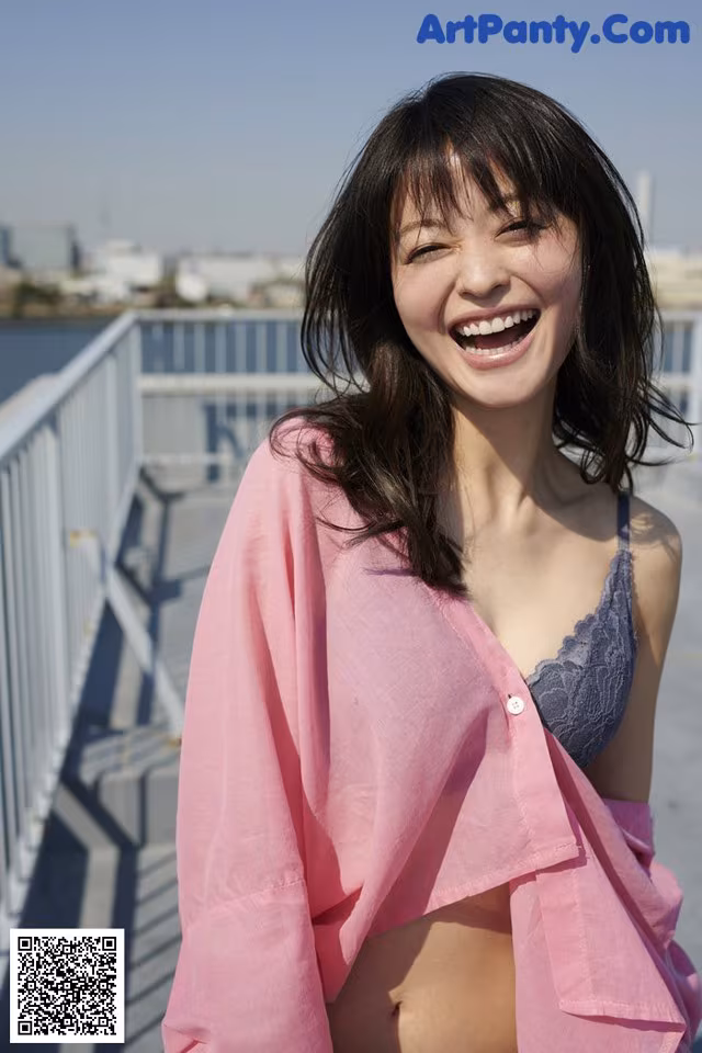 A woman in a pink shirt smiles at the camera.