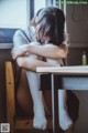 A woman sitting at a desk with her head in her hands.