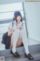 A woman sitting on the steps of a building with a backpack.