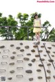 A woman in a yellow dress standing on a climbing wall.