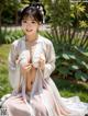 A woman in a white kimono sitting on the grass.