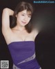 A woman in a purple dress posing for a picture.