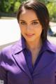 A woman in a purple shirt is posing for a picture.