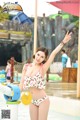 A woman in a bikini standing in a water park.